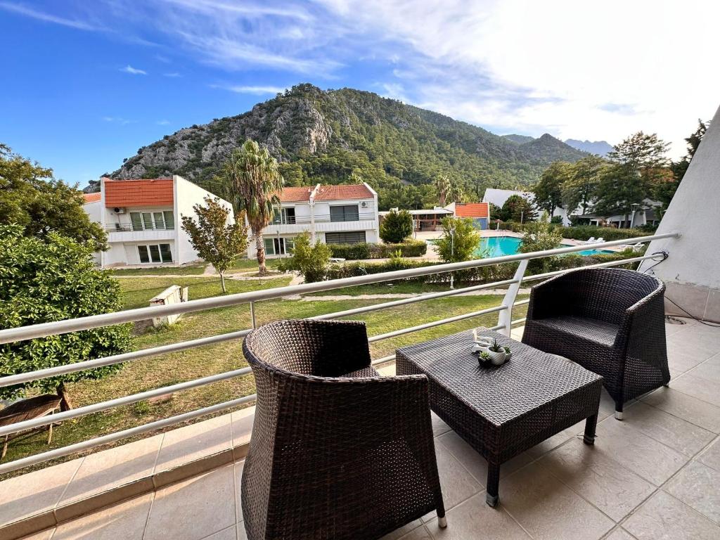 einen Balkon mit einem Tisch, Stühlen und einem Berg in der Unterkunft Magic mountain villas in Antalya