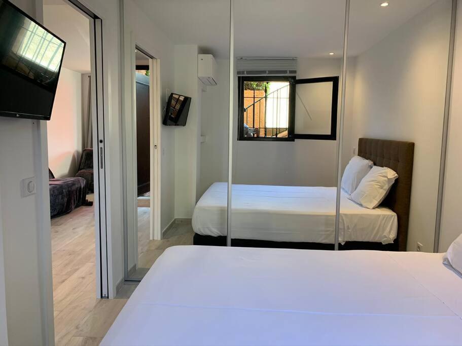 Una habitación de hotel con dos camas y un espejo. en Appartement neuf 4km Saint-Tropez, en Saint-Tropez