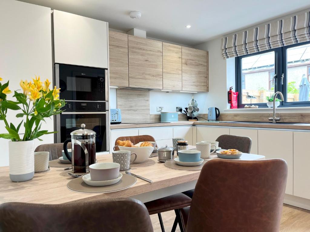 ペンザンスにあるBeautiful 3 Bed Townhouse with Parking, close to Sea Frontのキッチン(木製テーブル、食べ物付)
