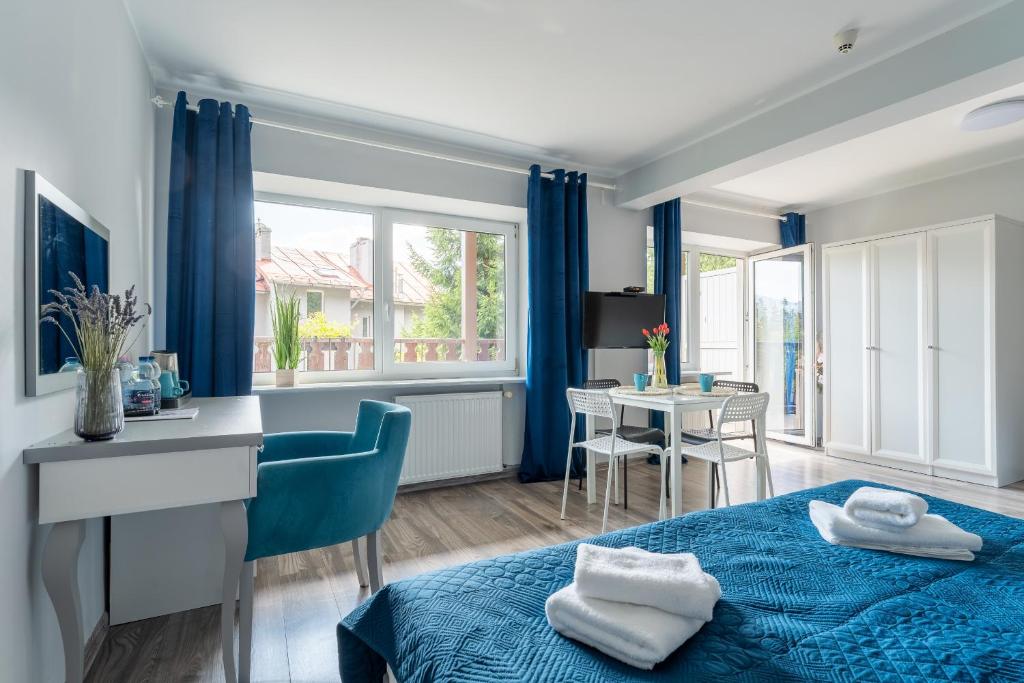 シュクラルスカ・ポレンバにあるWilla Sonata - w otoczeniu natury z widokiem na góryのベッドルーム(青いベッド1台、テーブル付)