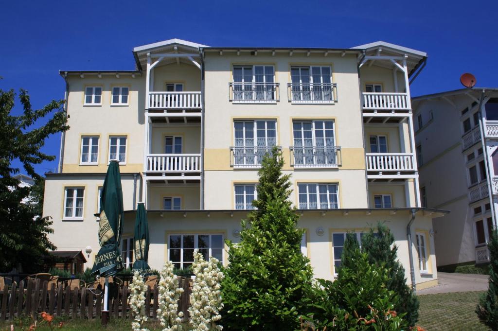 ein großes weißes Gebäude mit Bäumen davor in der Unterkunft Hotel Garni Meeresgruß in Sassnitz
