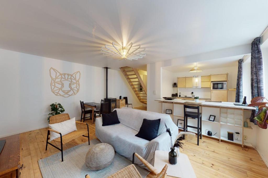 ein Wohnzimmer mit einem Sofa und einer Küche in der Unterkunft Quai Saint-Leonard - La Renommée liege in Lüttich