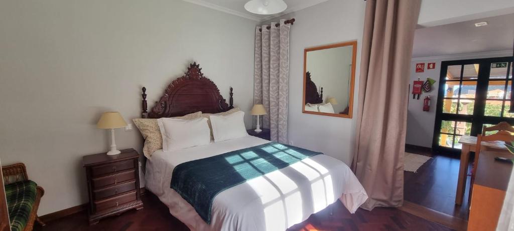 a bedroom with a large bed and a window at Studio em Machico in Machico