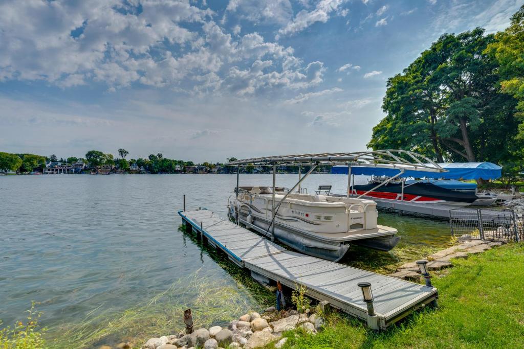 two boats docked at a dock on a lake at Lakefront Wisconsin Escape with Boat Dock and Kayaks! in Oconomowoc