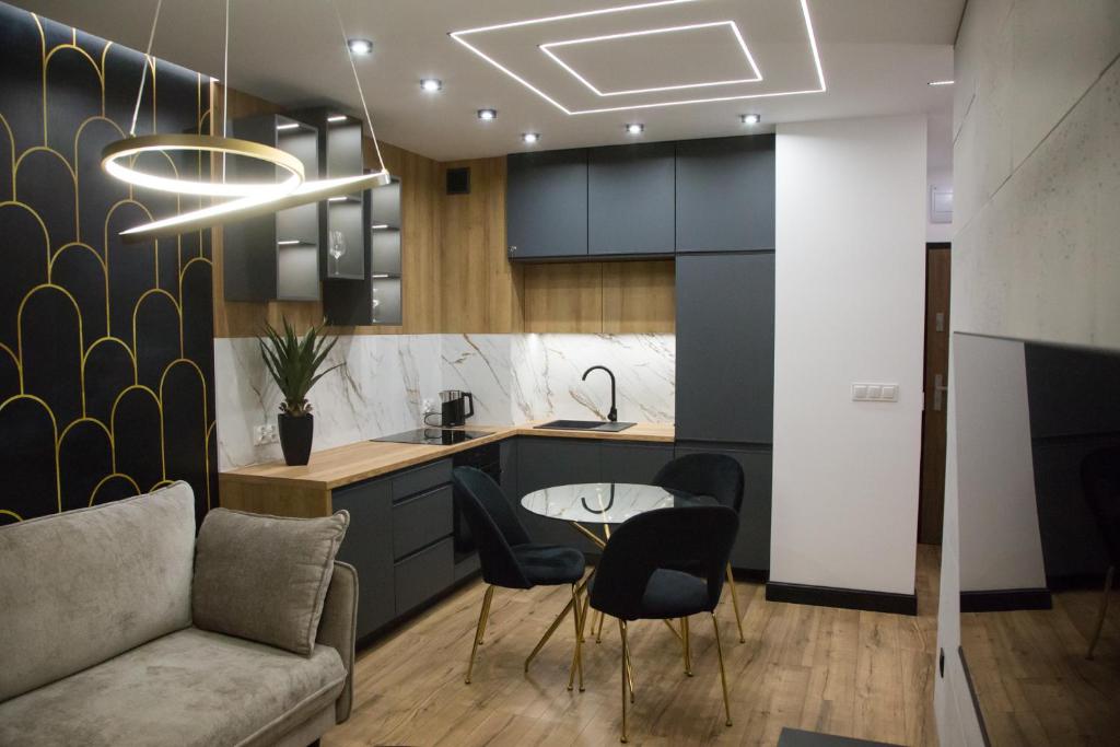 een keuken met een bank en een tafel en stoelen bij Apartament POSEJDON Gliwice in Gliwice