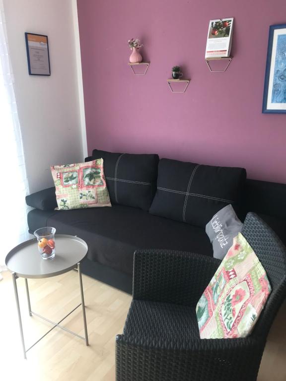 a living room with a black couch and a table at Pension Doreen Nieswand in Gamstädt