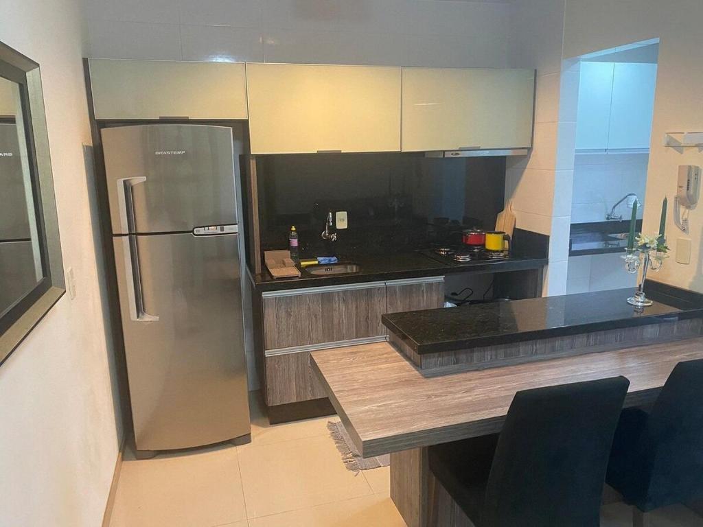 a kitchen with a stainless steel refrigerator and a counter at RCM Vilas - Loft mobiliado in Joinville