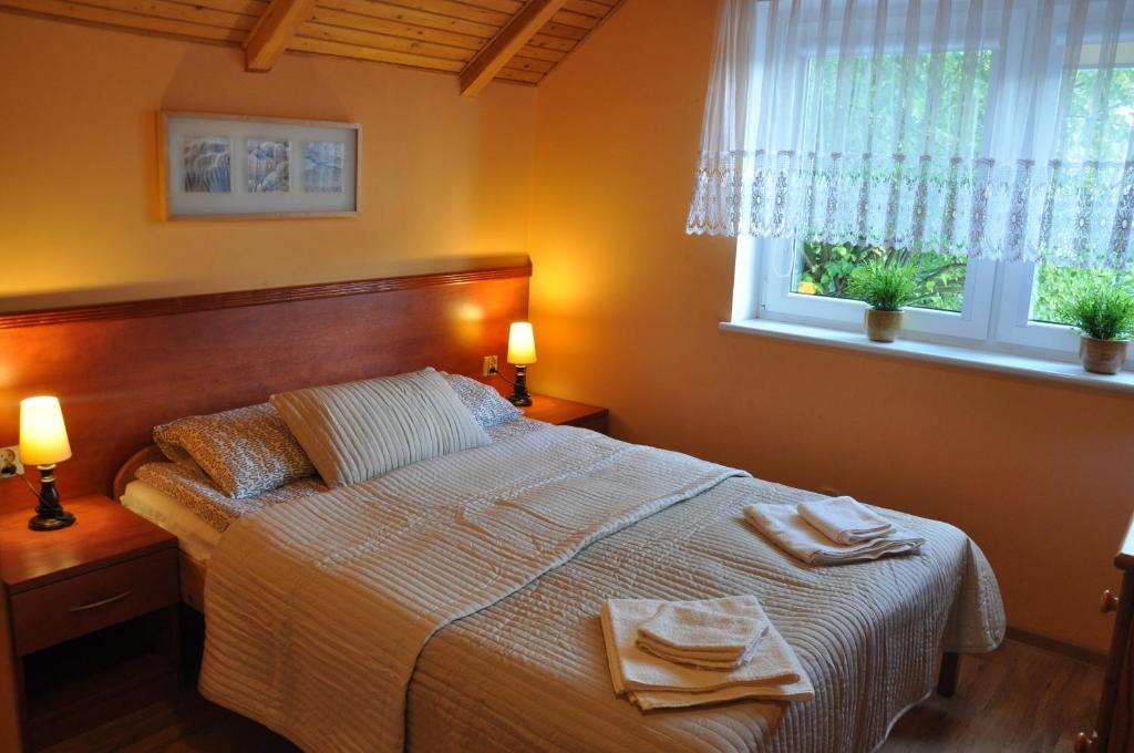 a bedroom with a bed with two towels on it at Central Łeba Suites in Łeba
