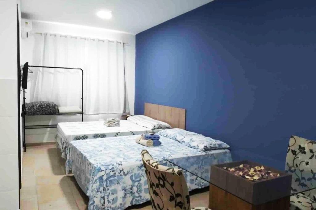 - une chambre avec 2 lits et un mur bleu dans l'établissement RCM Vilas - STUDIO n 06, à Joinville