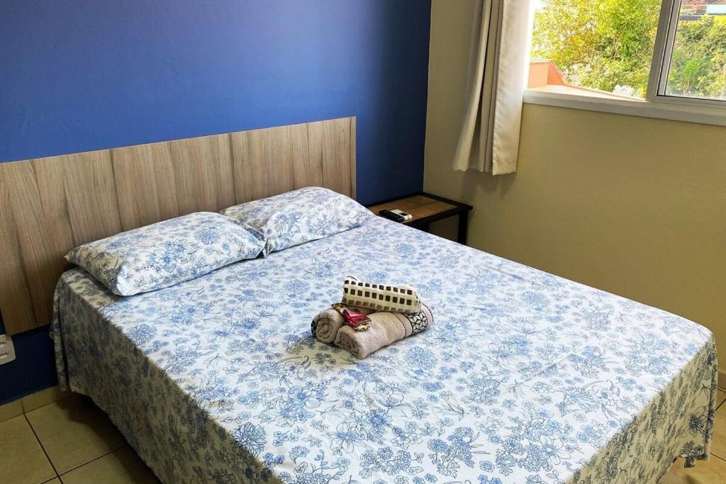 um quarto com uma cama com um cobertor azul e branco em RCM Vilas - STUDIO n 14 em Joinville