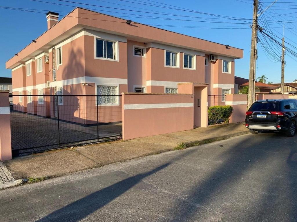 a car parked in front of a pink house at RCM Vilas - STUDIO n18 in Joinville