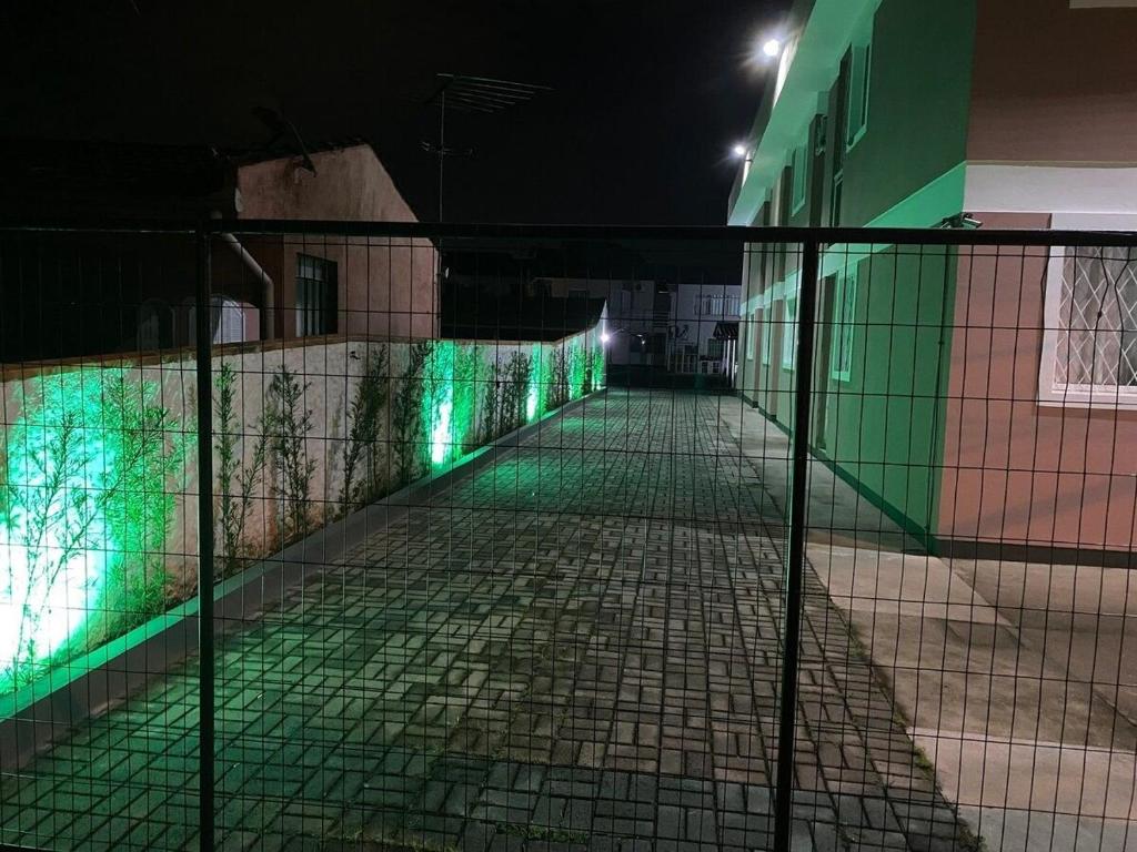 a fence with green lights on the side of a building at RCM Vilas - Studio n18 Deluxe in Joinville