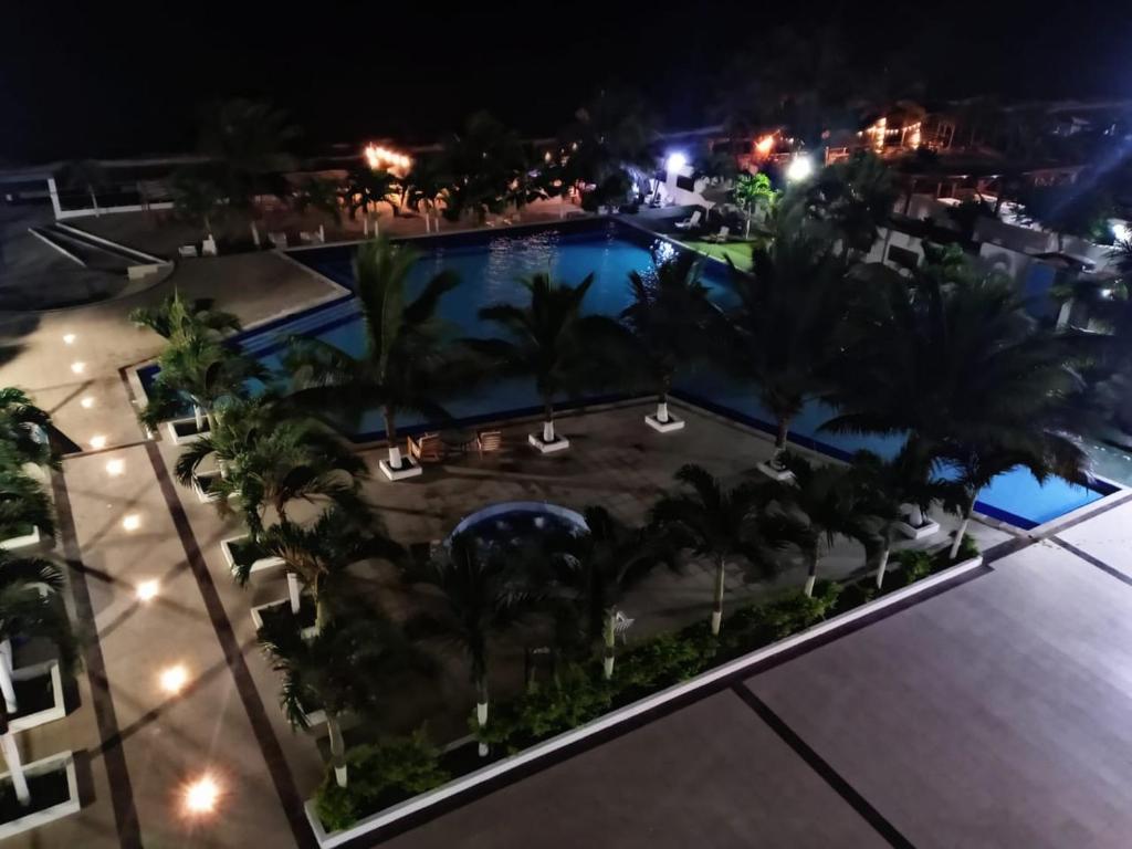 - une vue aérienne sur la piscine la nuit dans l'établissement Hermoso departamento frente al mar, à Tonsupa