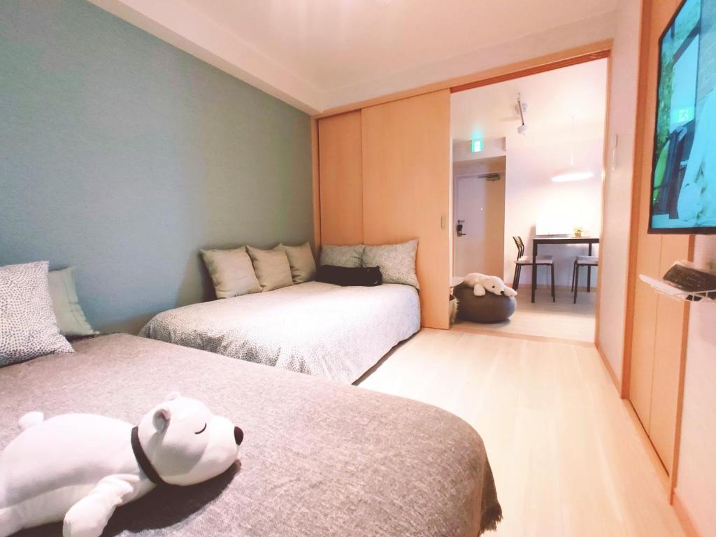1 dormitorio con 2 camas y un osito de peluche en la cama en SY Mansion - Vacation STAY 15495, en Saitama