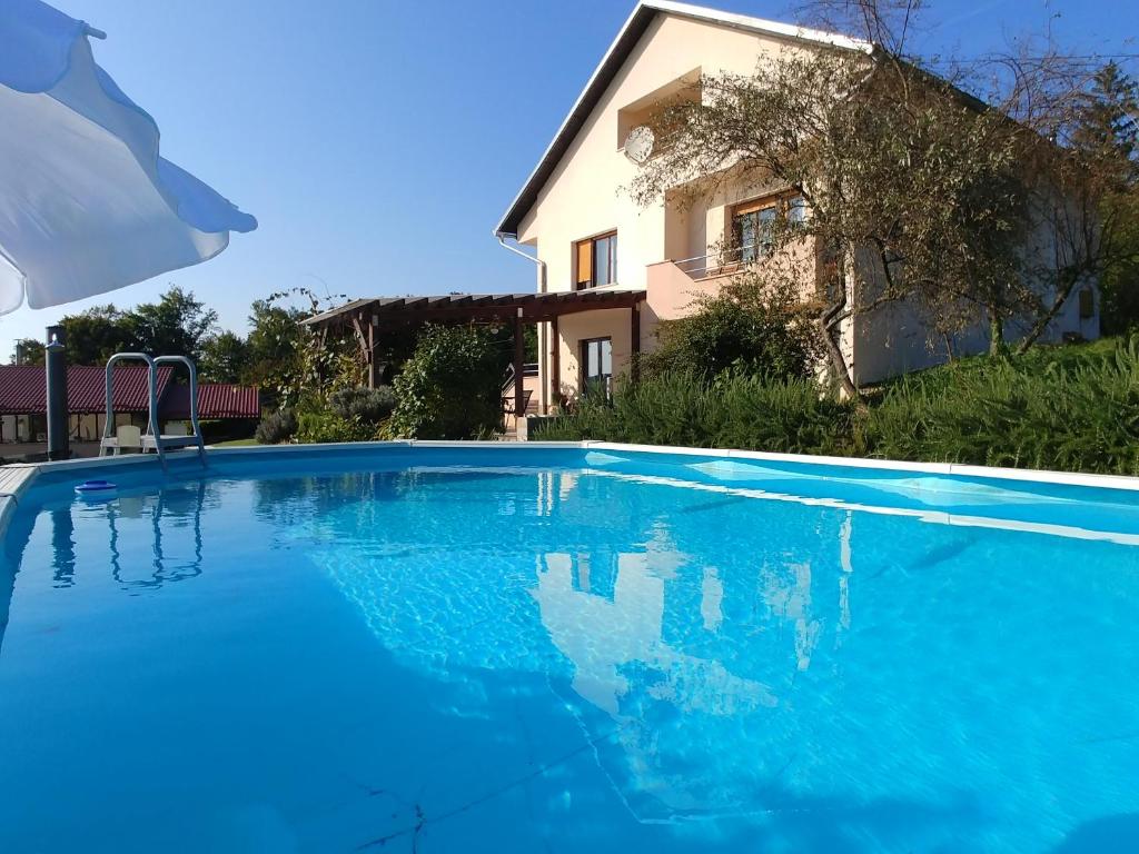 a large blue swimming pool in front of a house at Apartman Arena in Štrigova