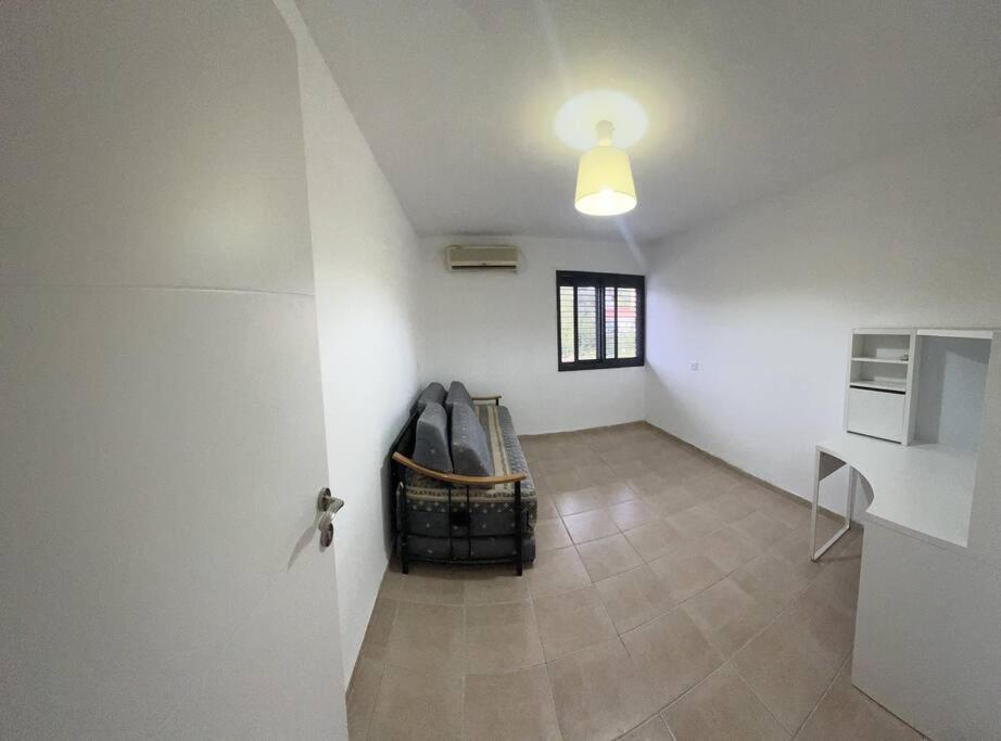 דירת הנופש שלכם في كريات شمونة: غرفة معيشة مع كرسي في زاوية الغرفة