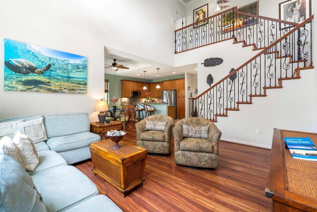 a living room with a couch and a staircase at Mauna Lani Fairways 1101 in Waikoloa