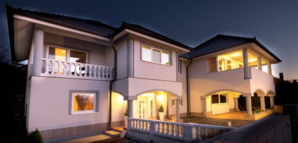 a large white house with a balcony at night at Vila24 Levice in Levice