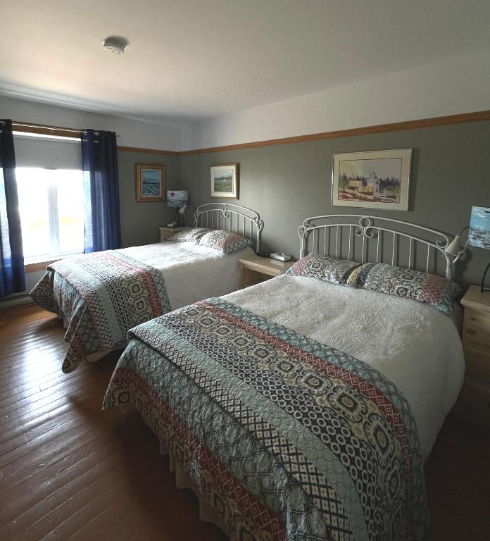 Rúm í herbergi á Auberge Marcel Gagnon