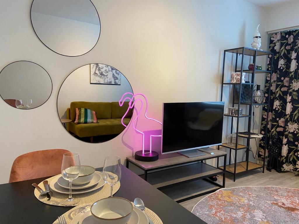 a living room with a table and a tv at Funky City Apartment in Rovaniemi