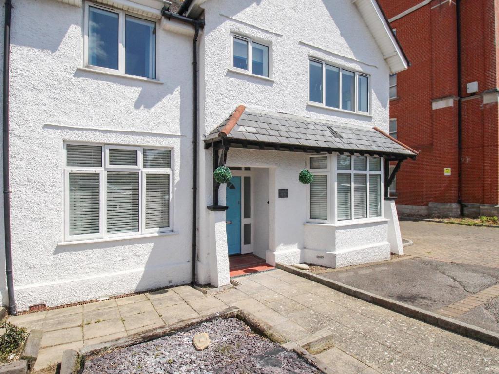 ein weißes Haus mit blauer Tür in der Unterkunft The White Cottage in Weymouth