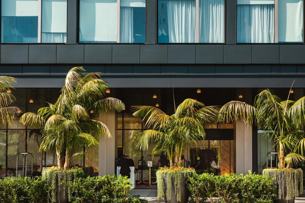 ein Gebäude mit Palmen davor in der Unterkunft The Godfrey Hotel Hollywood in Los Angeles