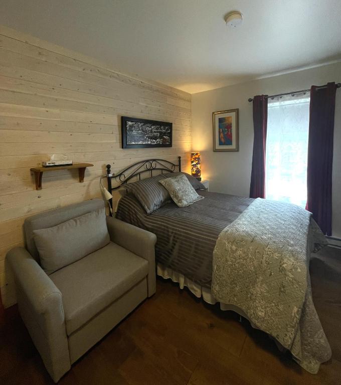 Rúm í herbergi á Auberge Marcel Gagnon