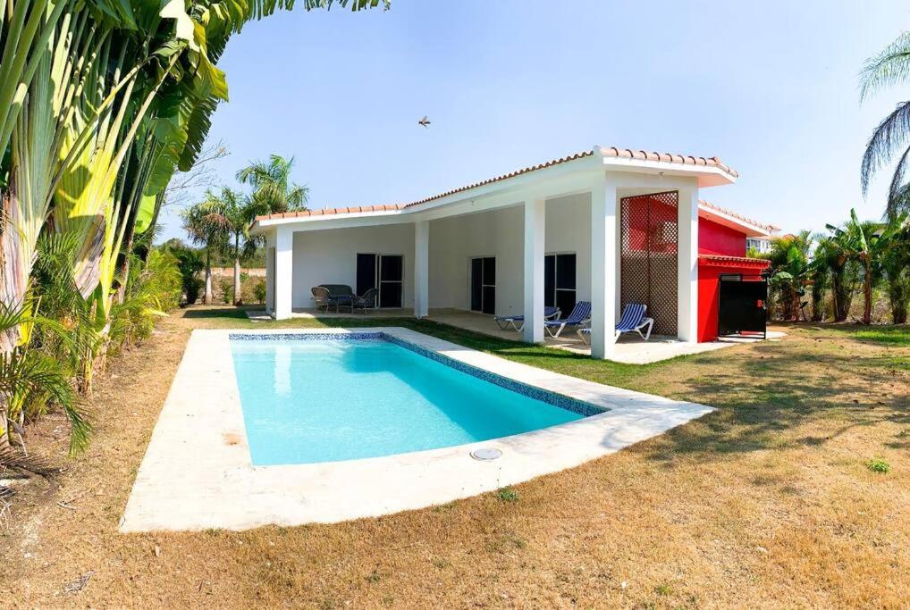 una casa con piscina frente a ella en Villa Sueño Caribeño N 91 en Boca Chica