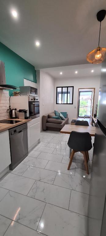 cocina y sala de estar con suelo de baldosa grande en Appartement cosy Champagnole en Champagnole