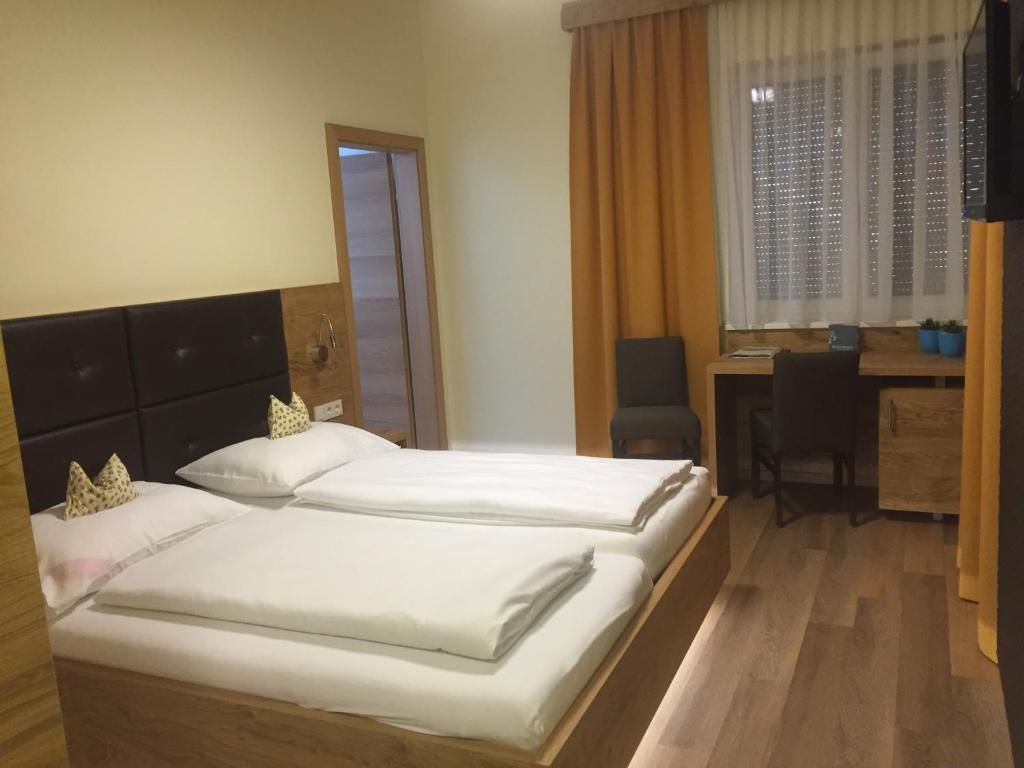ein Hotelzimmer mit 2 Betten, einem Schreibtisch und einem Schreibtisch in der Unterkunft Schnepfenhof in Jois