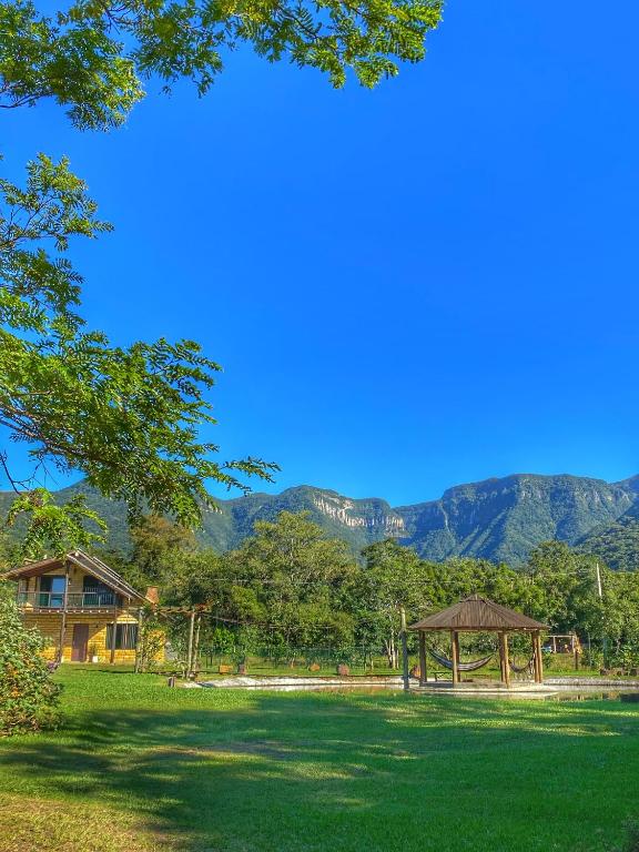 a park with a gazebo and mountains in the background at Pousada & Camping Nativos dos Canyons in Praia Grande
