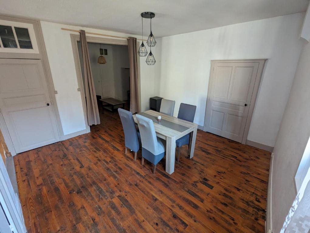 - une salle à manger avec une table et des chaises sur du parquet dans l'établissement Charme et Authenticité, à Perreux