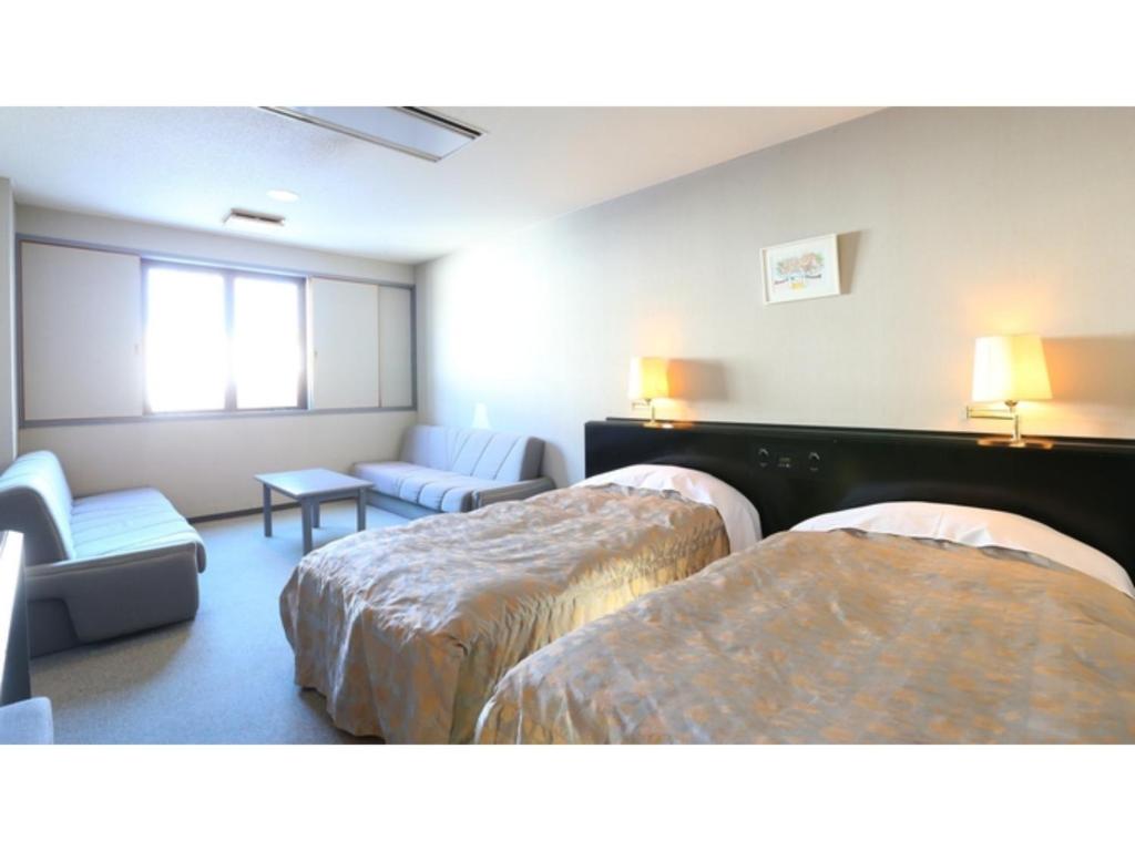 a hotel room with two beds and a couch at Hotel Silk in Madarao - Vacation STAY 79652v in Iiyama