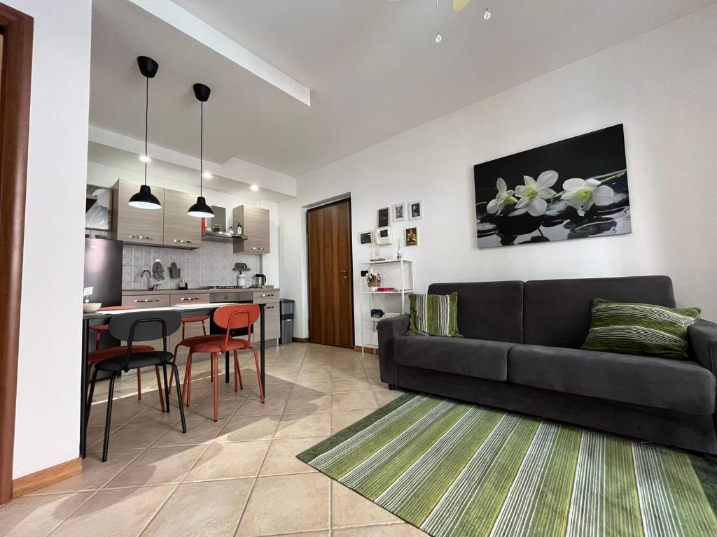 a living room with a black couch and a kitchen at Appartamento Montebello in Terni