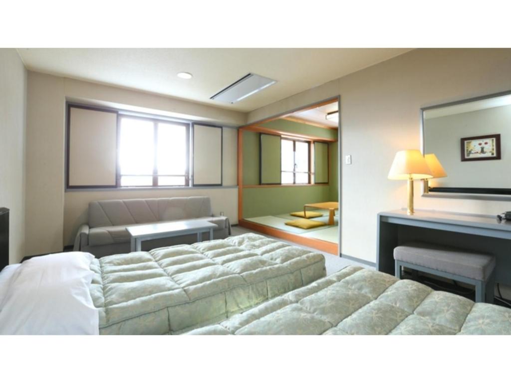 a bedroom with a large bed and a desk at Hotel Silk in Madarao - Vacation STAY 77724v in Iiyama