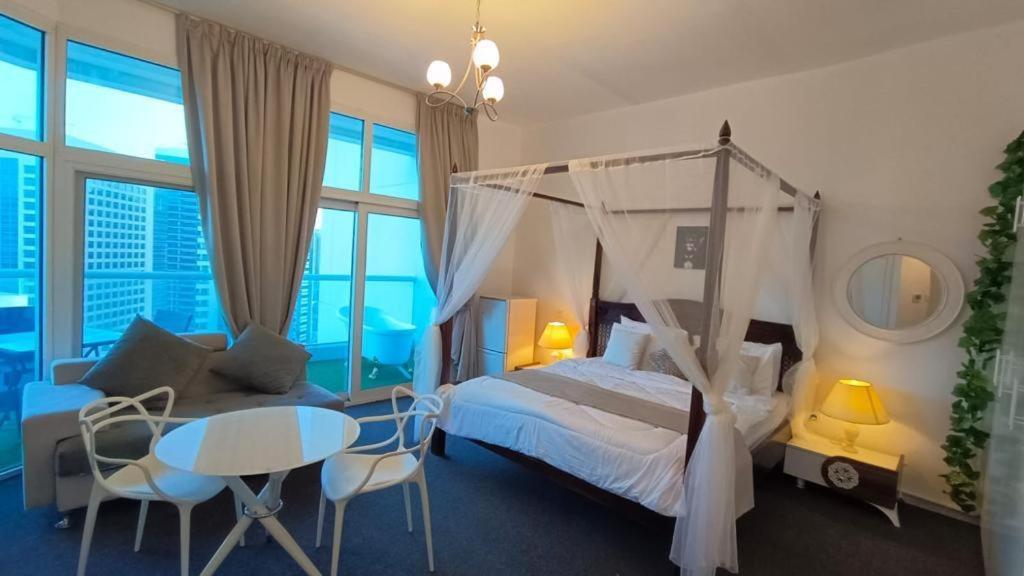1 dormitorio con cama con dosel, mesa y sillas en Near Atana Hotel en Dubái