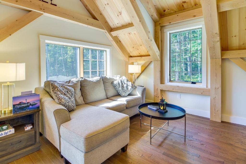 a living room with a couch and a table at Cozy Camden Cottage with Fire Pit and Trail Access in Camden