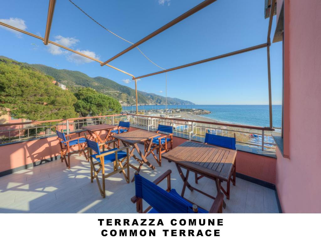 einen Balkon mit Tischen, Stühlen und Meerblick in der Unterkunft Affittacamere Lo Scoglio (Guesthouse) in Monterosso al Mare
