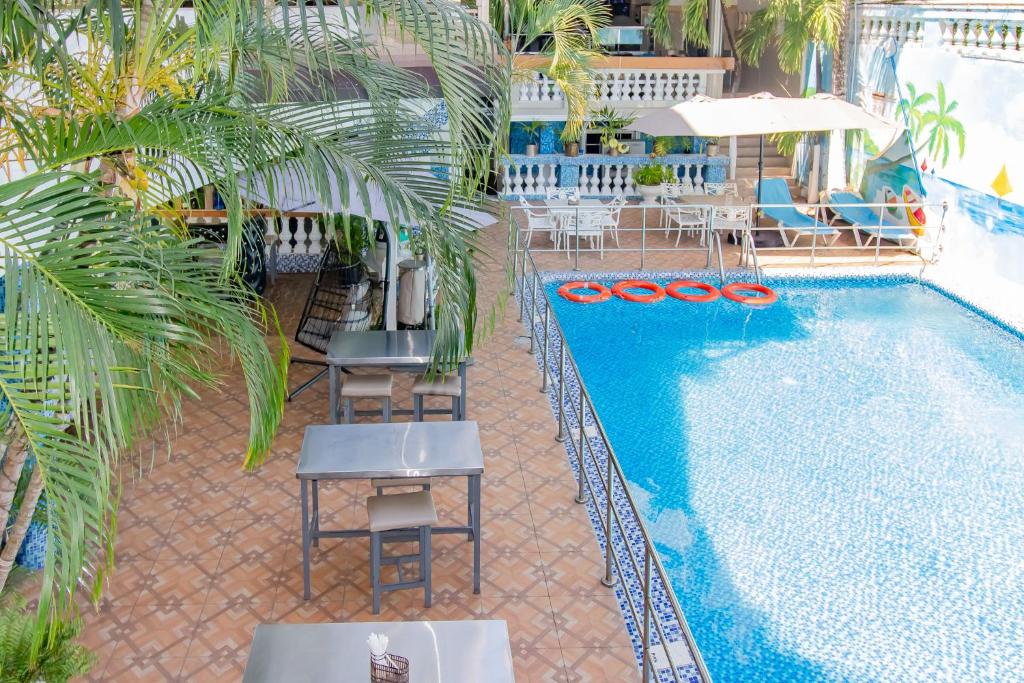 einen Blick über einen Pool mit Tischen und Stühlen in der Unterkunft Hotel La Casona Dorada in Santo Domingo