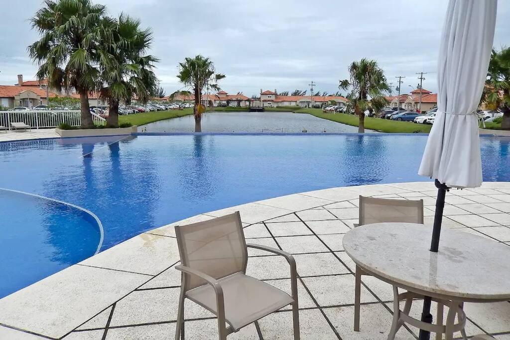 una mesa y sillas junto a una piscina en Casa Hermosa, en Xangri-lá