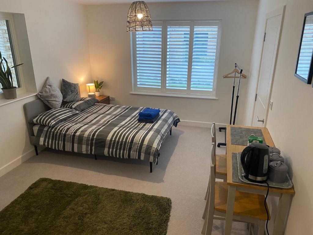 a bedroom with a bed and a table and a window at Very large double room with corner sofa and Sky TV in Newhaven