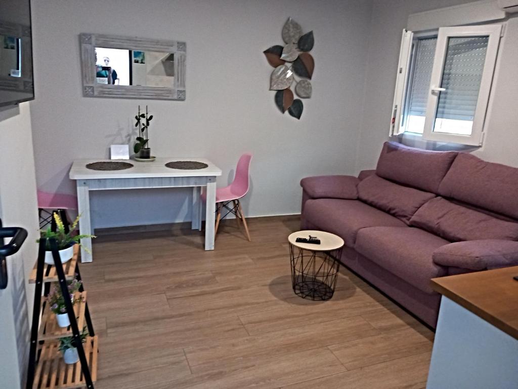 a living room with a purple couch and a table at Apartamento de la Haya, junto al Teatro Romano in Merida