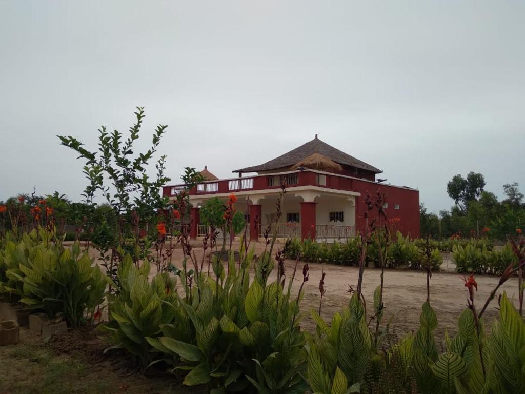 ein rotes und weißes Haus mit vielen Pflanzen in der Unterkunft Résidence Le Marlodj in Mar Lodj