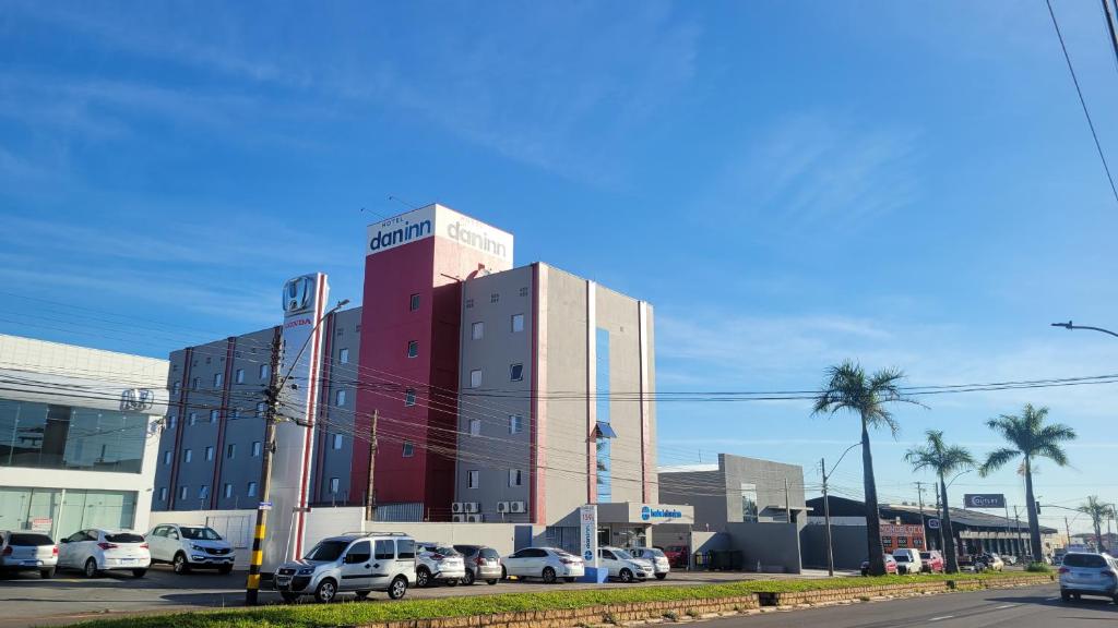 un gran edificio con coches estacionados en un estacionamiento en Hotel Dan Inn São Carlos, en São Carlos