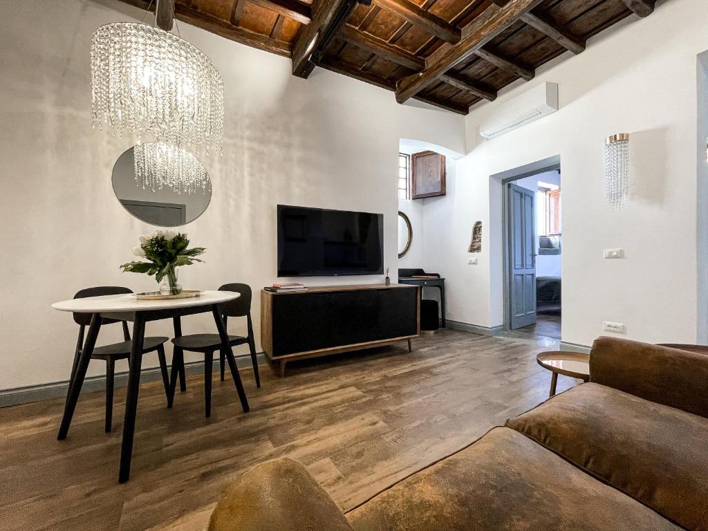 a living room with a table and a tv at DomusLu' - Casa di charme nel cuore di Roma in Rome