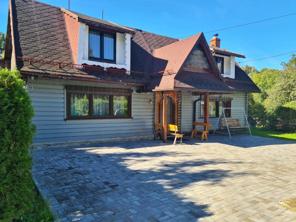 a house with a brick driveway in front of it at Domek Domino in Korbielów