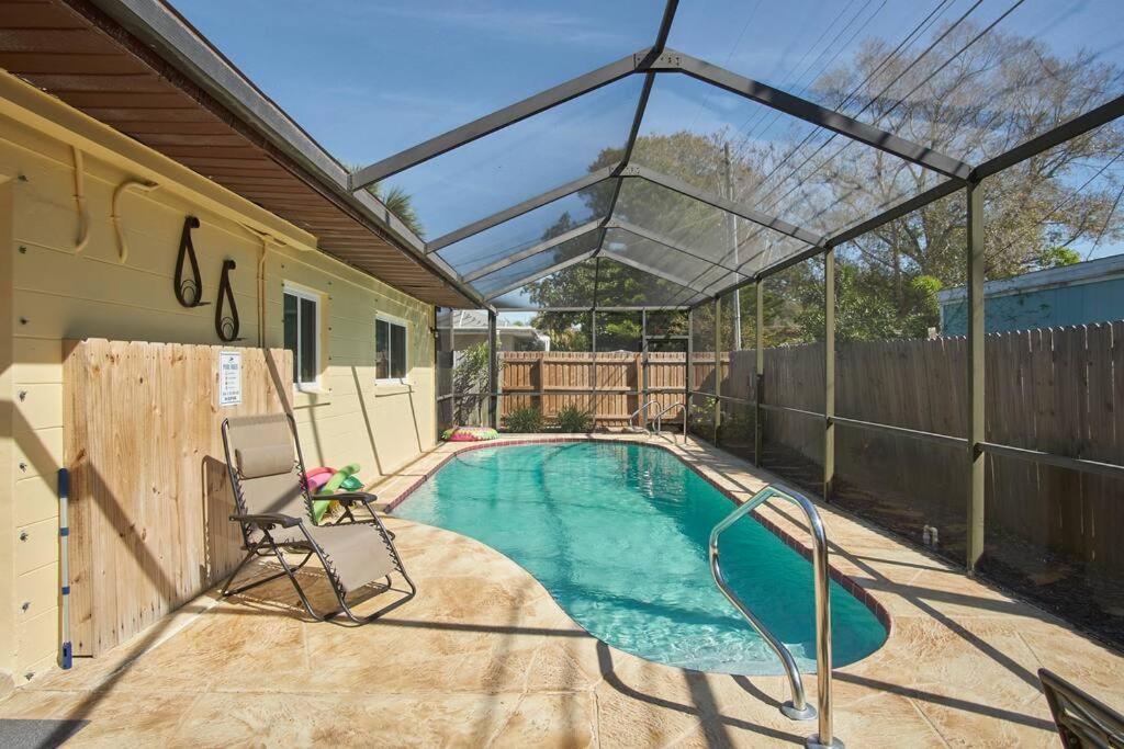 a swimming pool with a pergola next to a house at Heated pool home only 2.3miles from the beach in St. Petersburg