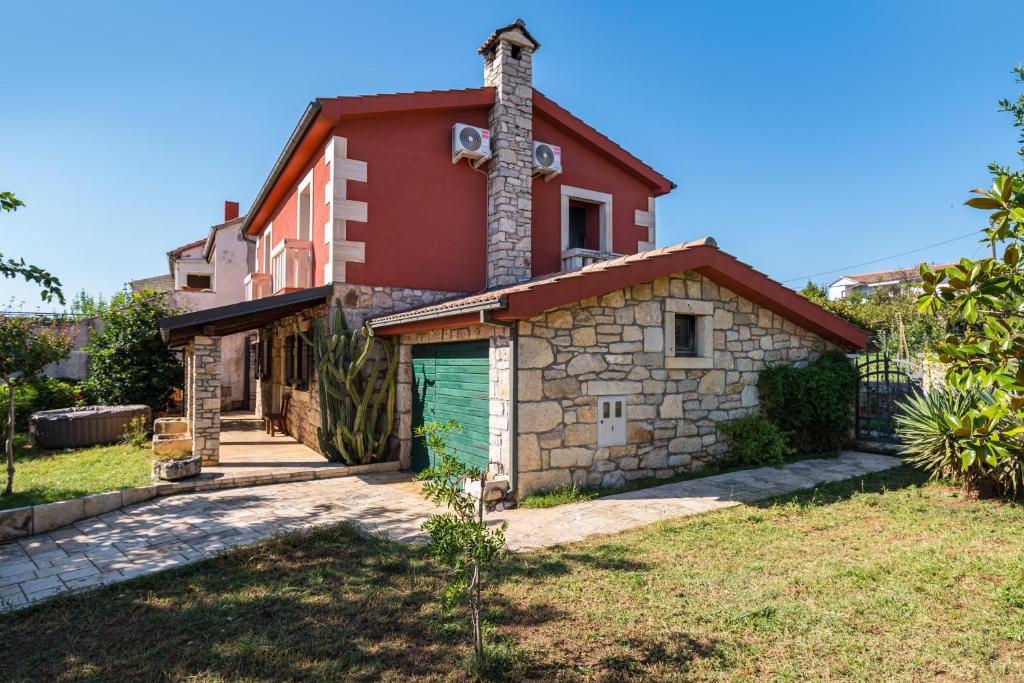 a house with a green garage in front of it at CROATIAN STONE GEM in Posedarje