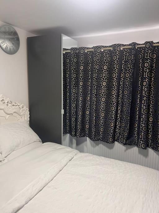 um quarto com uma cama e uma janela com cortinas em Cosy and warm studio apartment in Bexleyheath em Belvedere