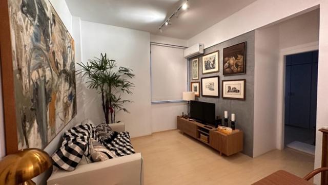 een woonkamer met een bank en een tv bij Praia de Ipanema in Rio de Janeiro
